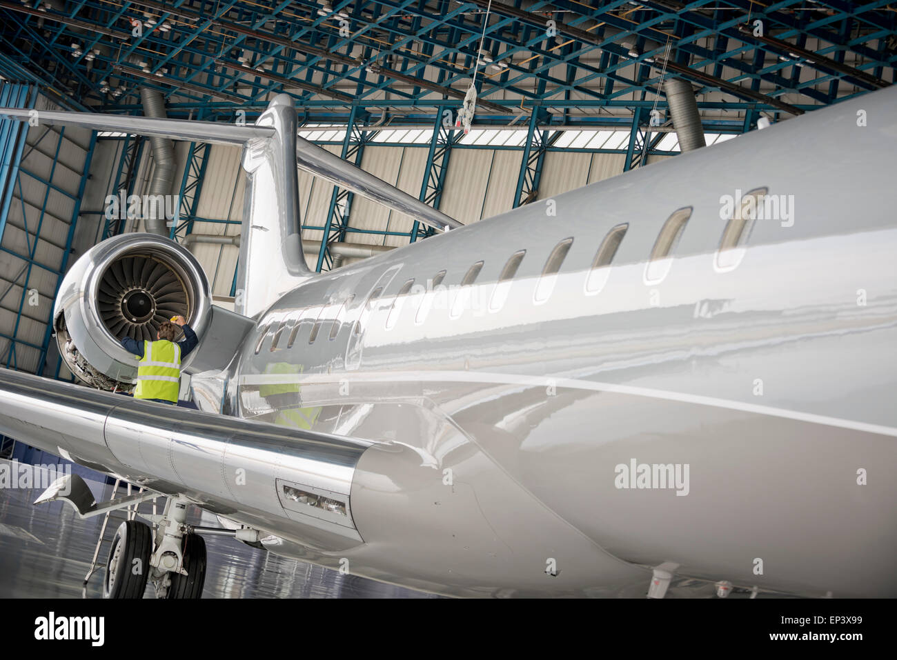 Aircraft mechanic inspecting airplane's jet engine Stock Photo