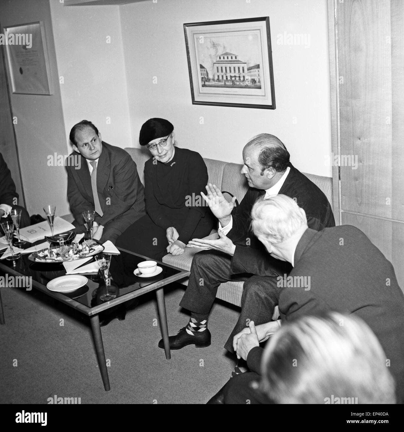 Männer sitzen mit einer älteren Dame in einem Besprechungsraum bei einem Glas Sekt in Hamburg, Deutschland 1950er Jahre. Men sit Stock Photo