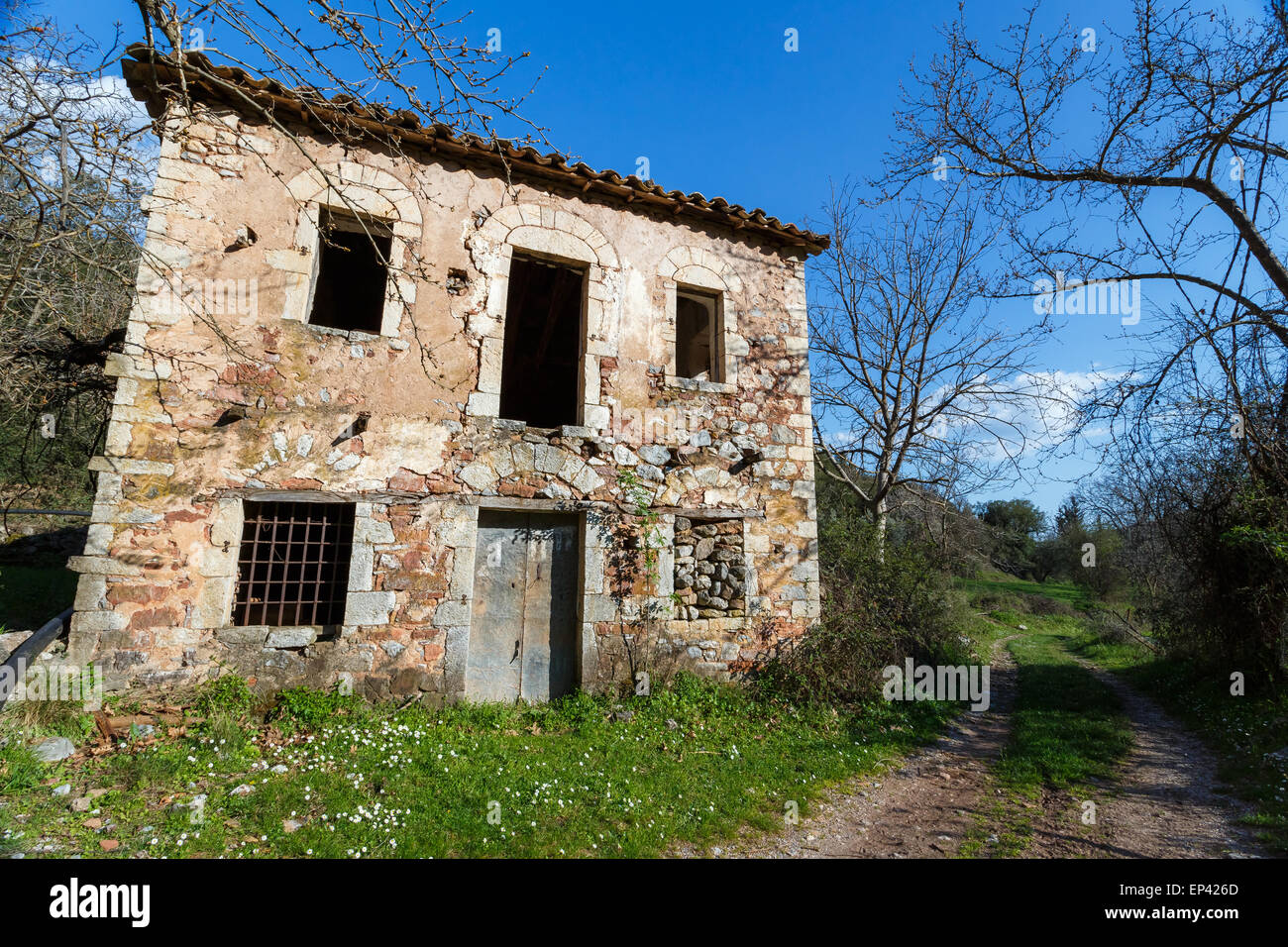 Old abandoned stone house ruins in countryside in Greece against a blue sky Stock Photo
