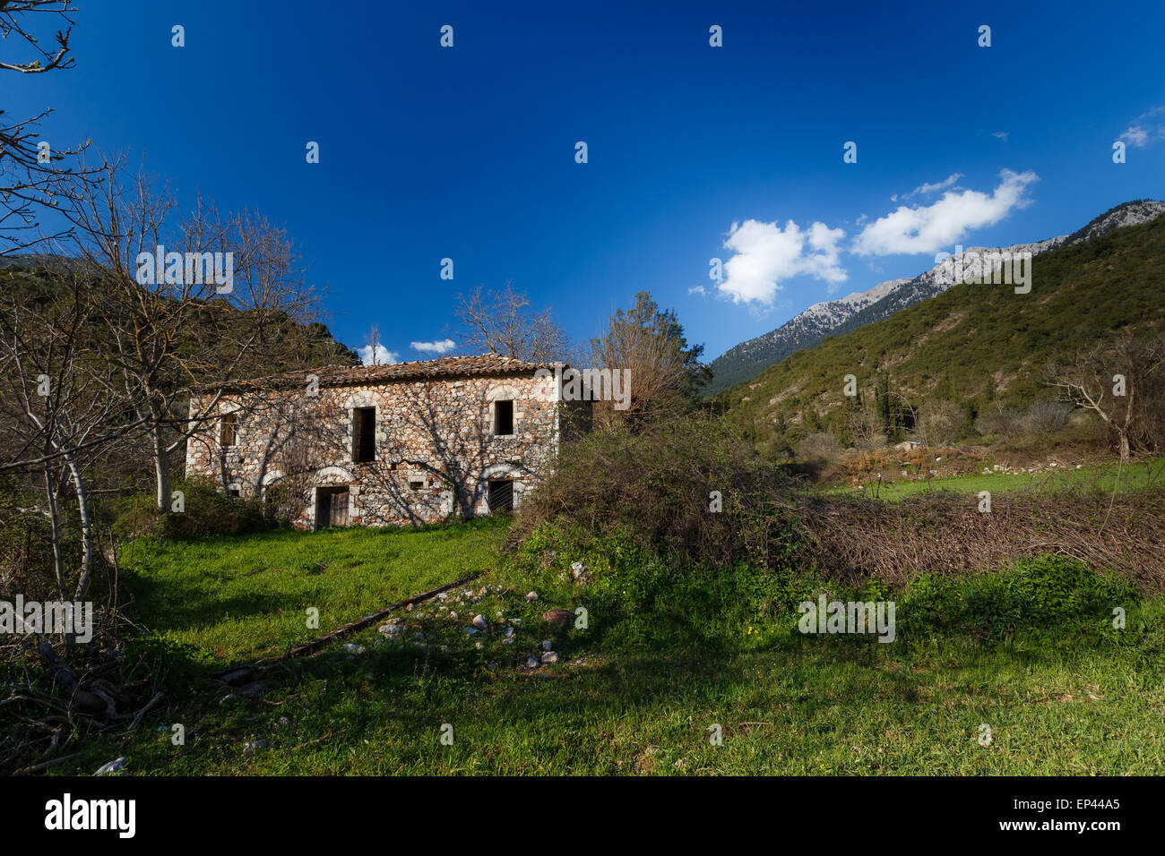 Old abandoned stone house ruins in countryside in Greece against a blue sky Stock Photo