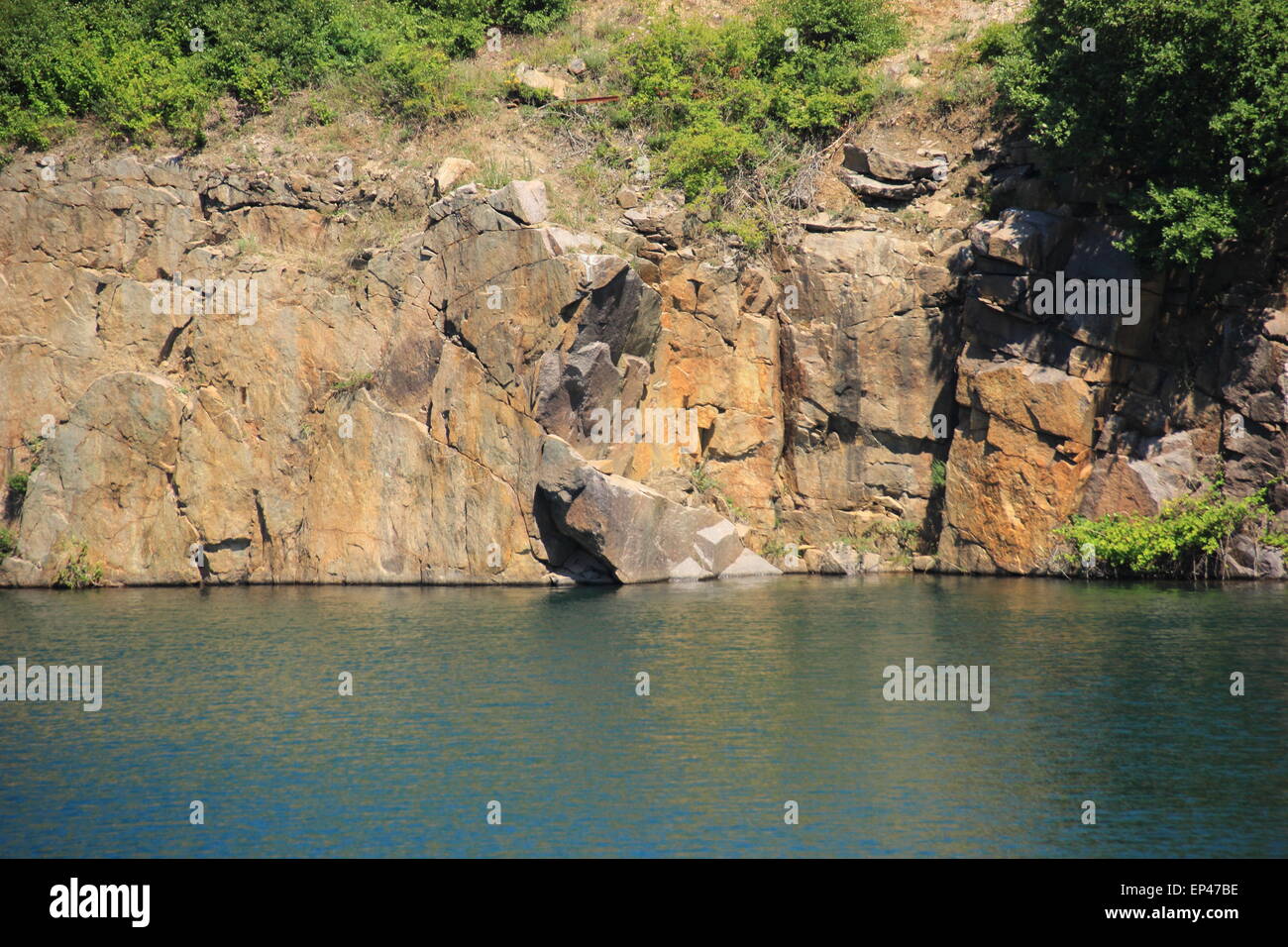 Lake with rocks and abrupt cliff hang Stock Photo