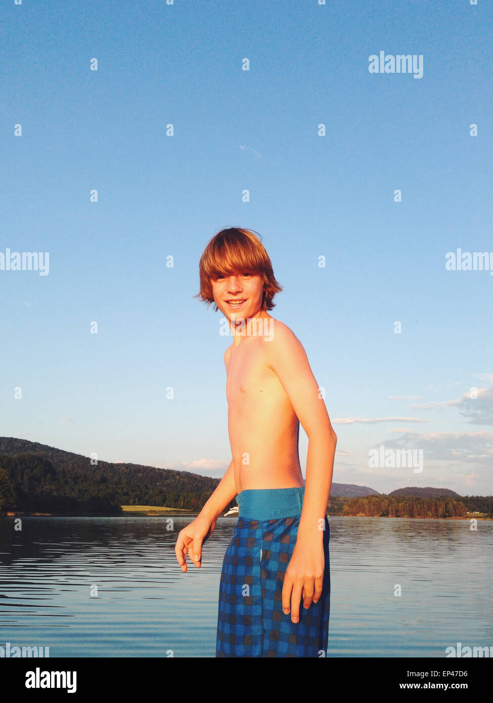 Portrait of a boy standing on a boat ready to go night swimming in mid summer, Norway Stock Photo
