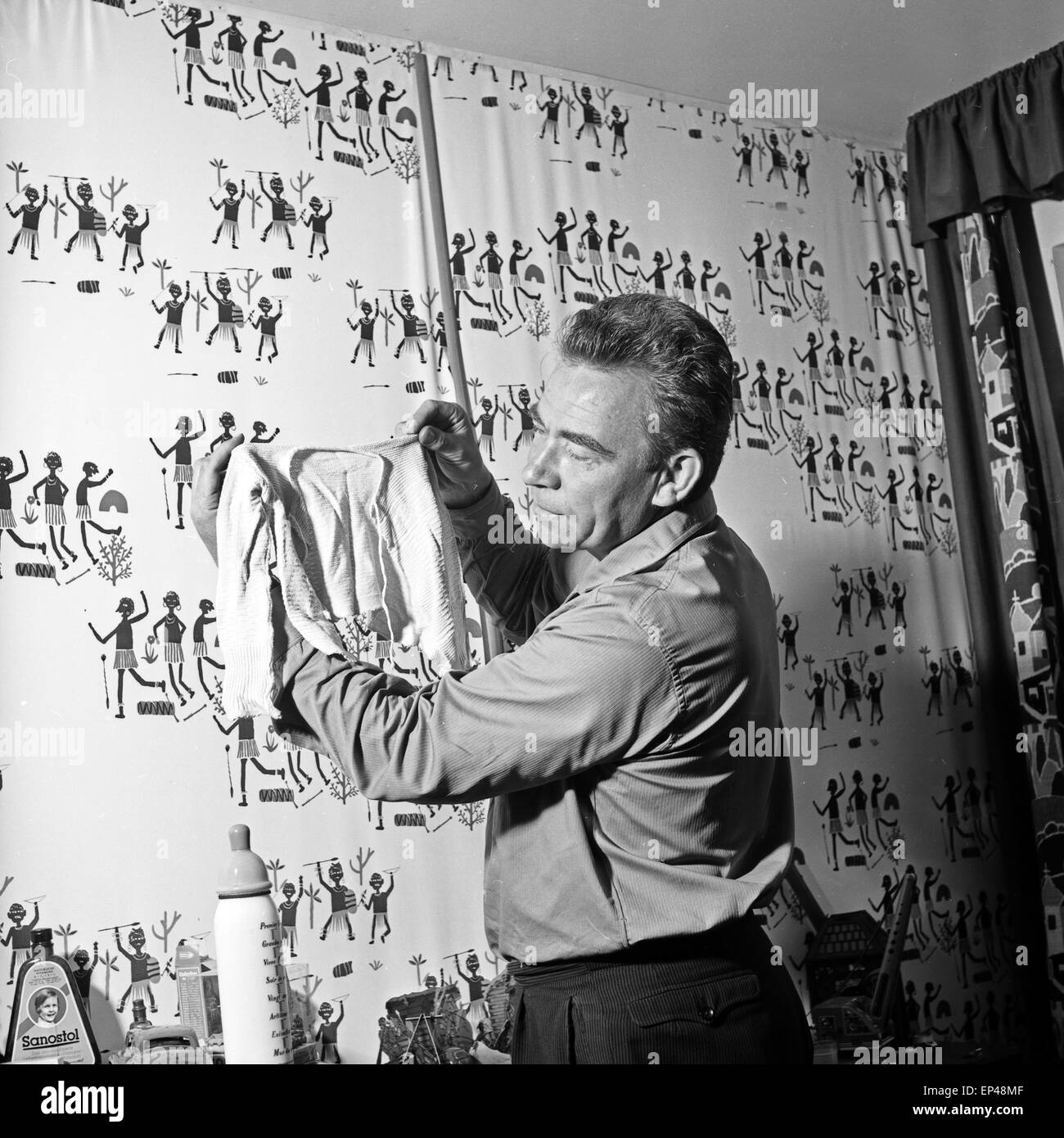 Peter Frankenfeld mit Strampelanzug und Fläschchen im Kinderzimmer des Hauses Erlenweg 16 in Wedel bei Hamburg, Deutschland 1950 Stock Photo