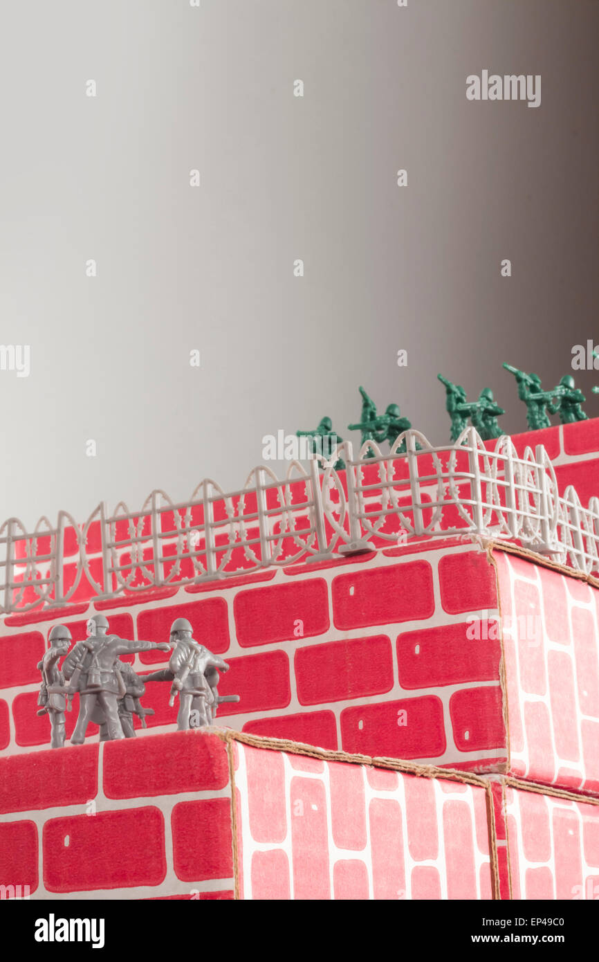 Gray toy army men up against impossible odds in uphill battle Stock Photo