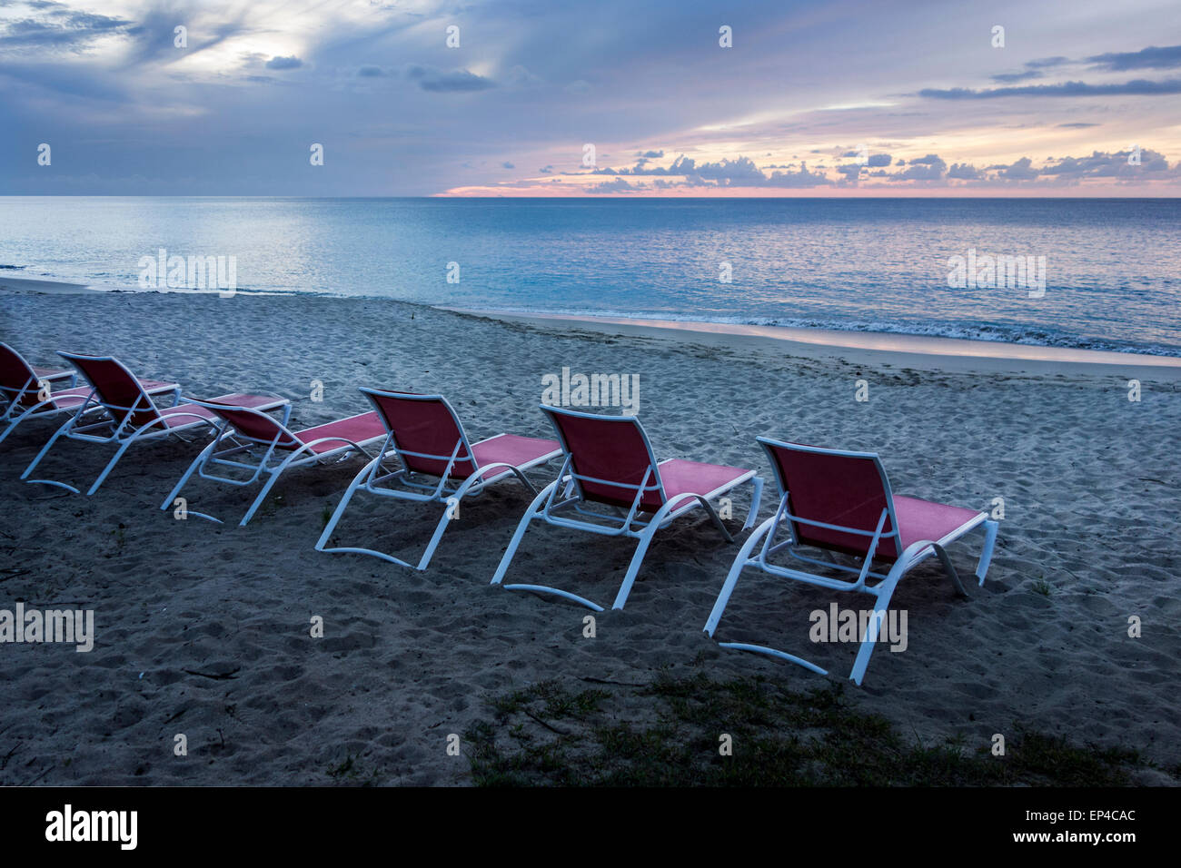 A view of a line of beach chairs from Cottages By the Sea resort on the west end of St. Croix, U.S. Virgin Islands at twilight. Stock Photo