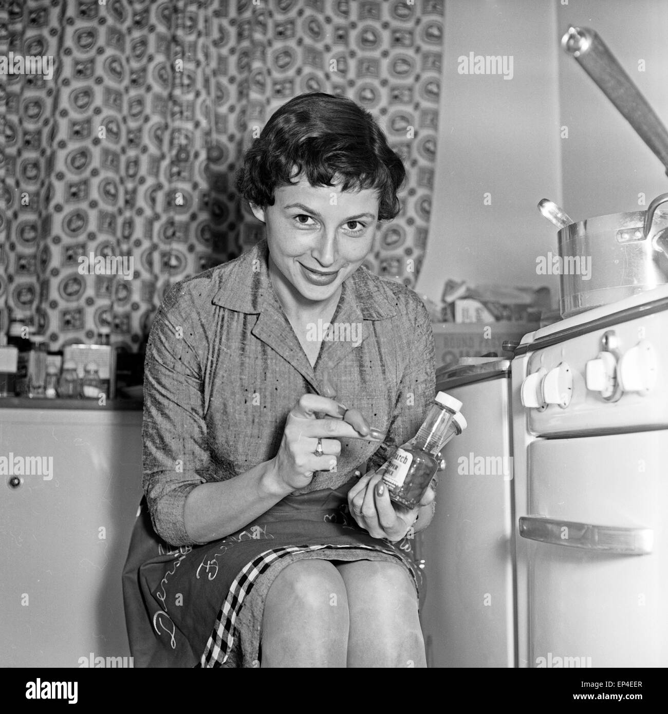 Junge Ruth Drasy sitzt in der Küche, Deutschland 1950er Jahre. Young Ruth Drasy sitting in her kitchen, Germany 1950s. Stock Photo