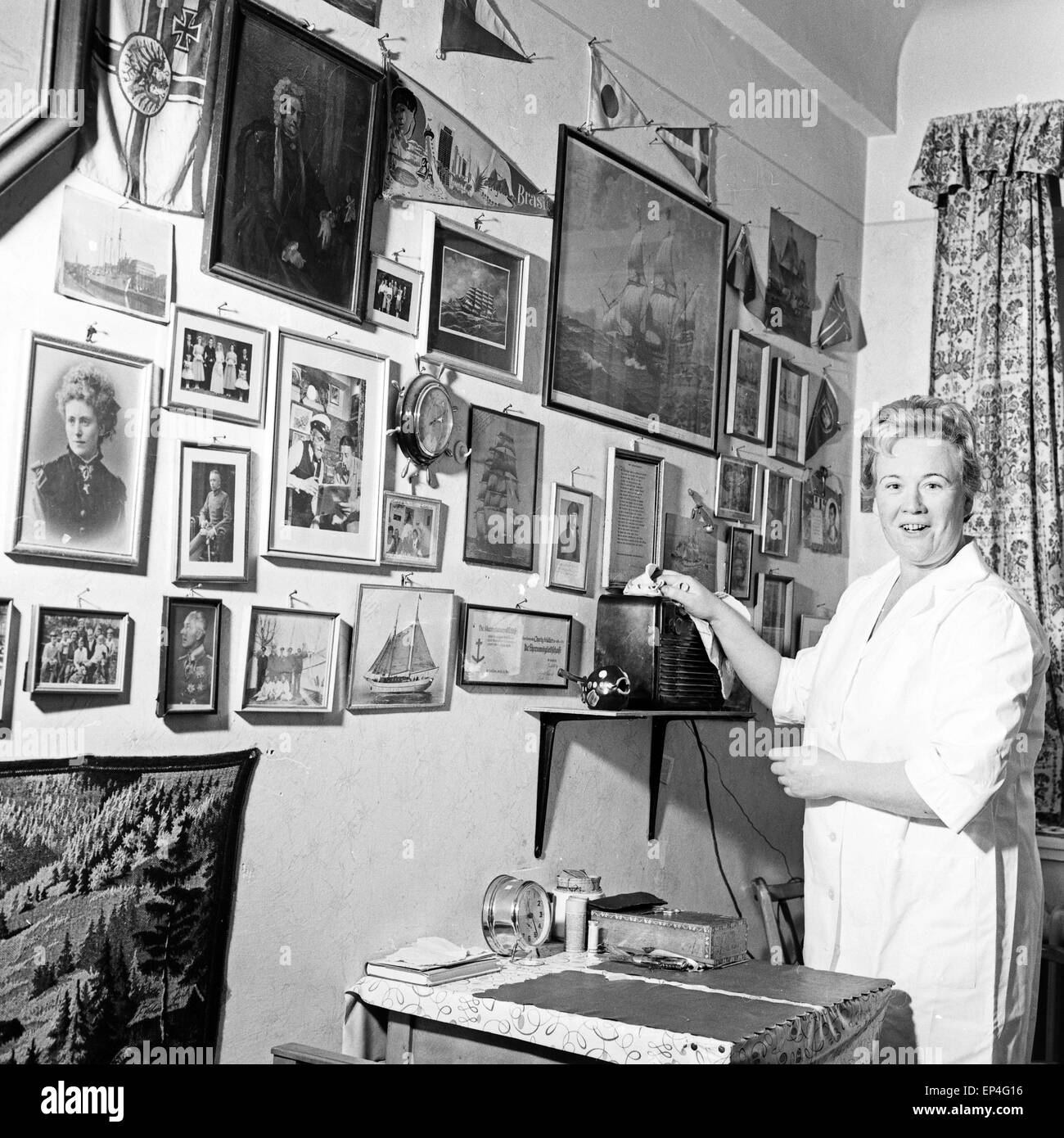 Ein Pflegekraft staubt die Bilder eines Bewohners der Stiftung Seefahrtsdank in Hamburg ab, Deutschland 1960er Jahre. A cleaning Stock Photo