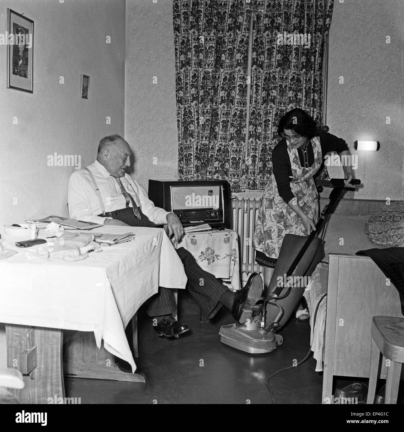 Ein Raumpflegerin staubsaugt im Zimmer eines Bewohners der Stiftung Seefahrtsdank in Hamburg ab, Deutschland 1960er Jahre. A cle Stock Photo