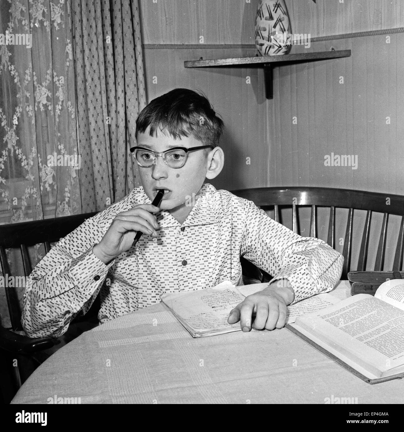 Ein Junge kämpft mit seinen Hausaufgaben, Deutschland 1960er Jahre. A school boy while his homework, Germany 1960s. Stock Photo