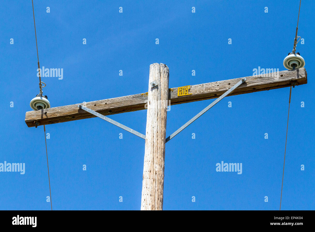 An electrical Pole with the word voltage etched into the wooden