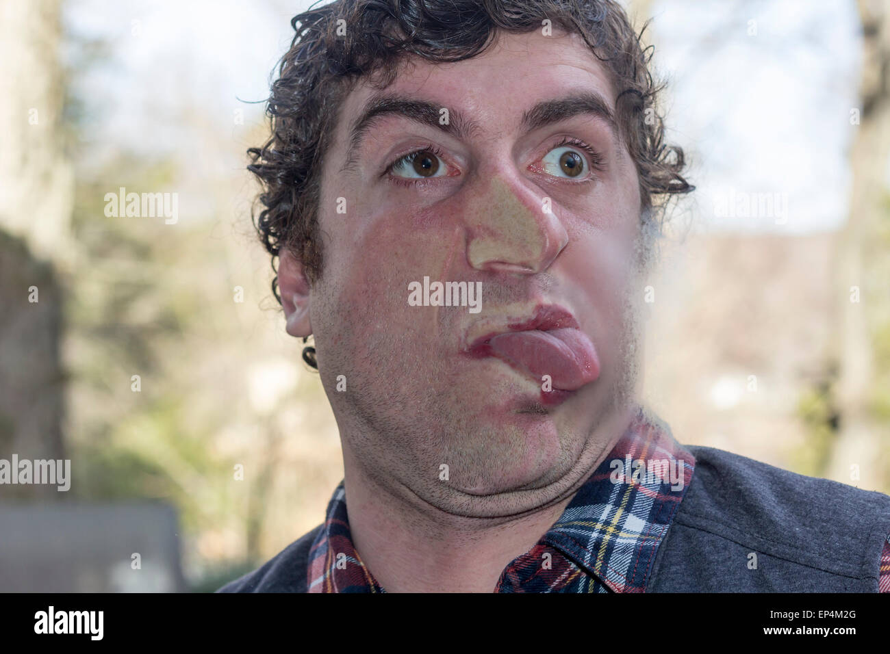 Crazy lunatic man smooshes face against glass surfaces Stock Photo
