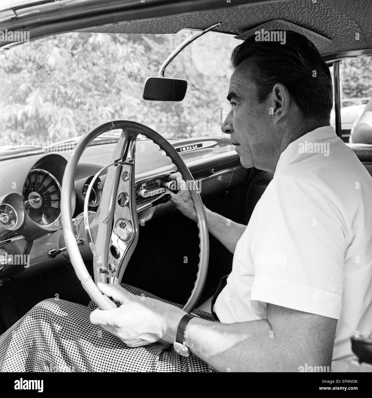 Deutscher Schauspieler und Entertainer Peter Frankenfeld am Steuer eines Chevrolet Impala, Deutschland 1960er Jahre. German a Stock Photo