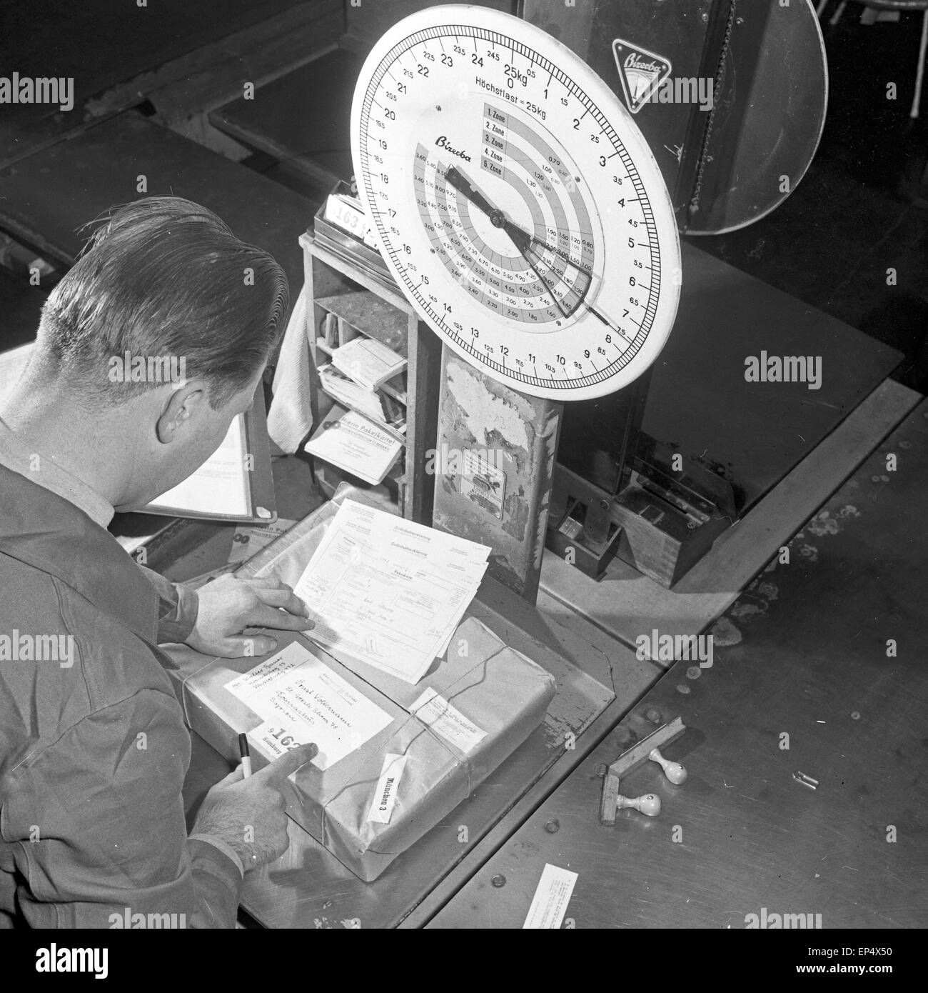Bildreportage über den Arbeitsalltag Deutschern Bundespost: Paketwaage, Deutschland 1960er Jahre. Photo coverage about every Stock Photo