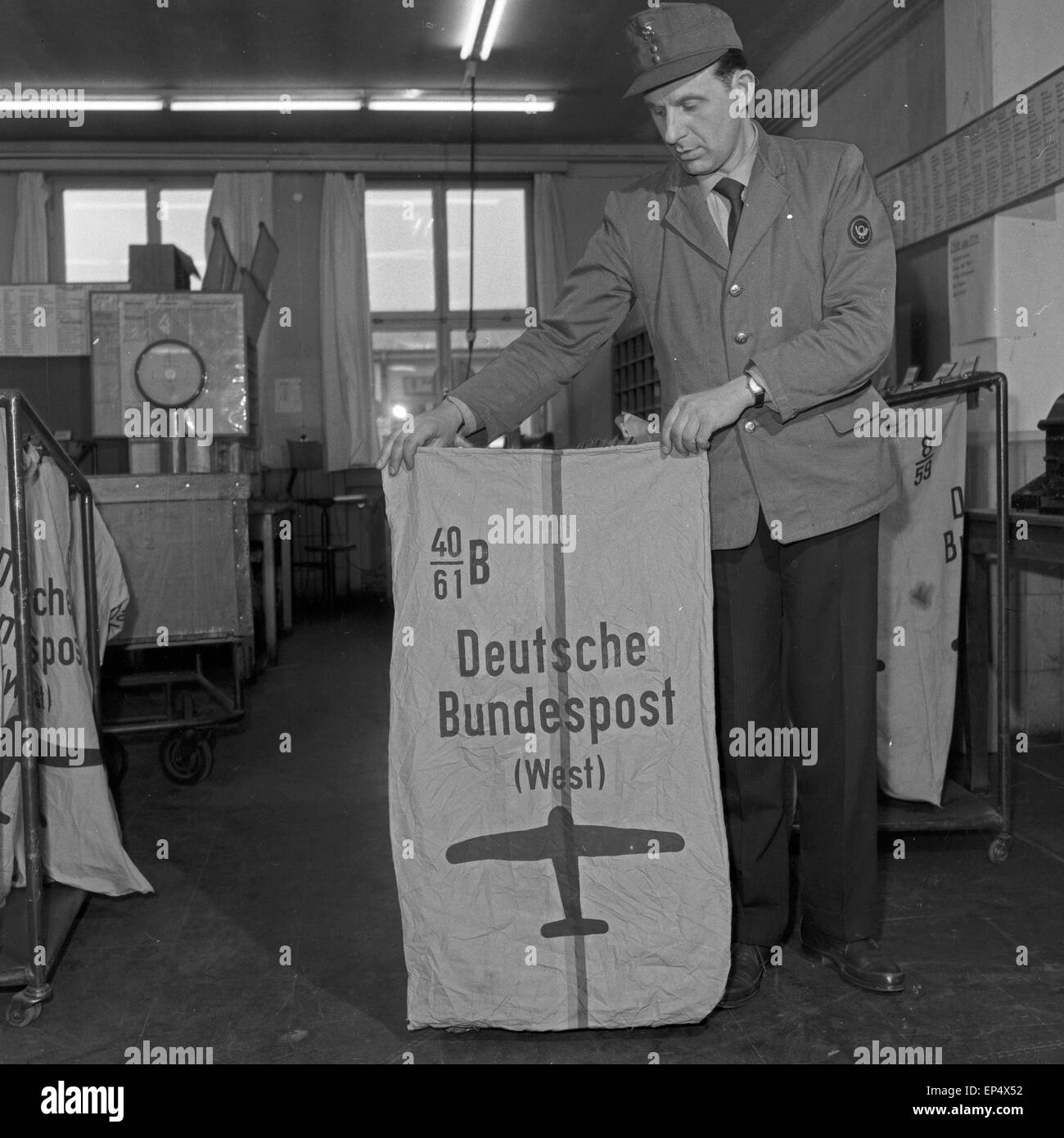 Bildreportage über den Arbeitsalltag Deutschern Bundespost: Beamter mit Luftpostsack, Deutschland 1960er Jahre. Photo coverag Stock Photo
