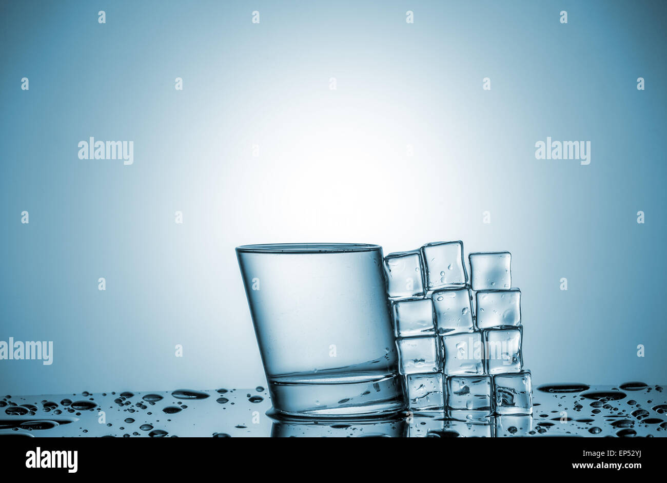 a glass of water and ice cubes, lying next, on blue background Stock ...