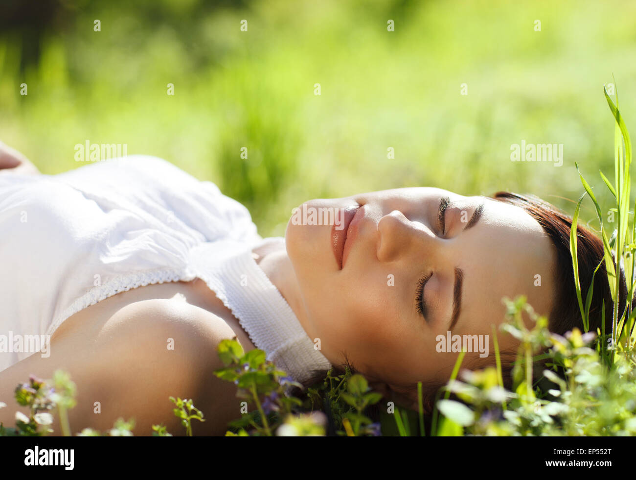 Beautiful young woman relaxing on green grass Stock Photo - Alamy