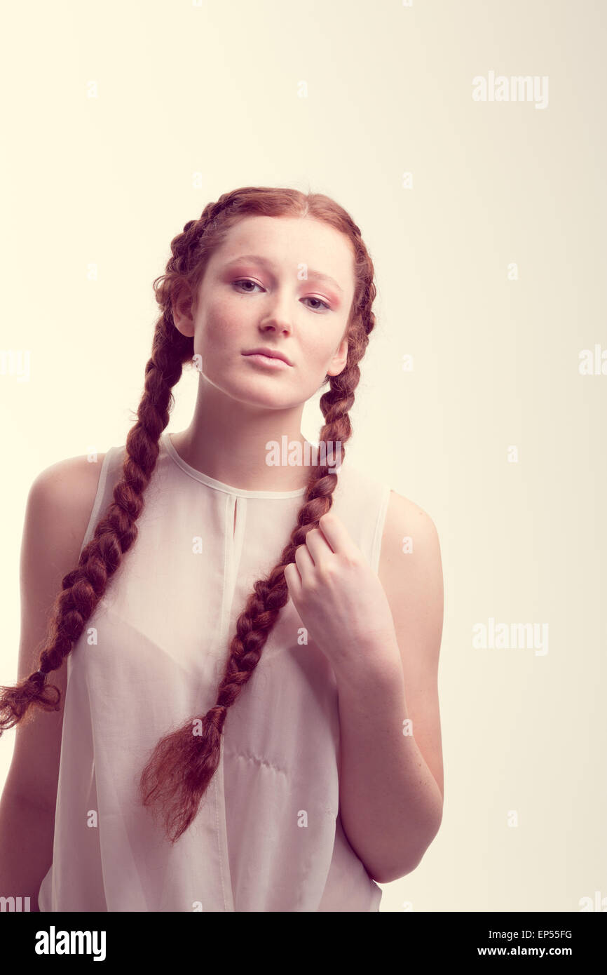 Portrait of a young woman with red hair and plaits looking serious. Stock Photo