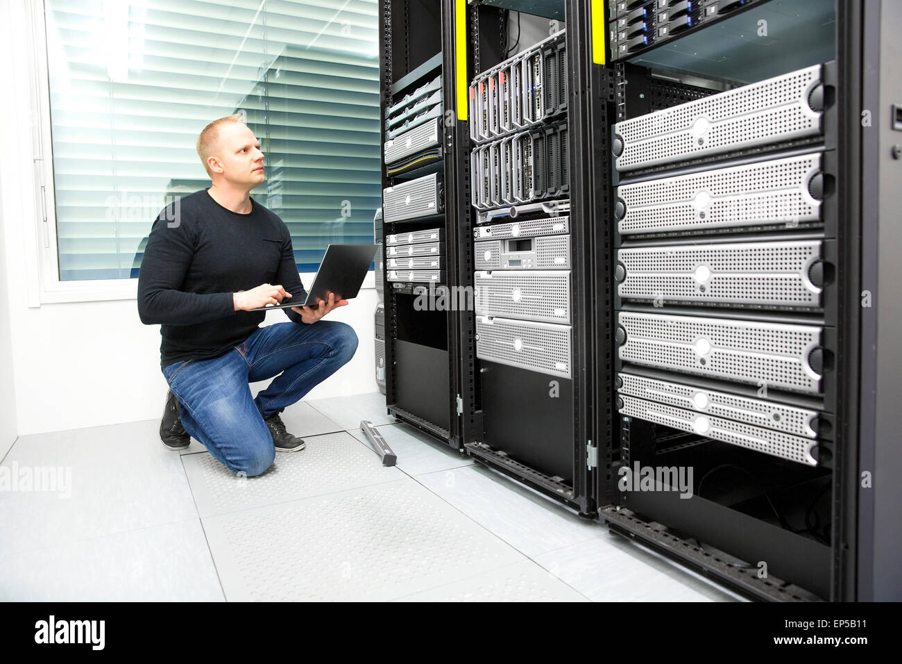 It consultant monitors servers in datacenter Stock Photo