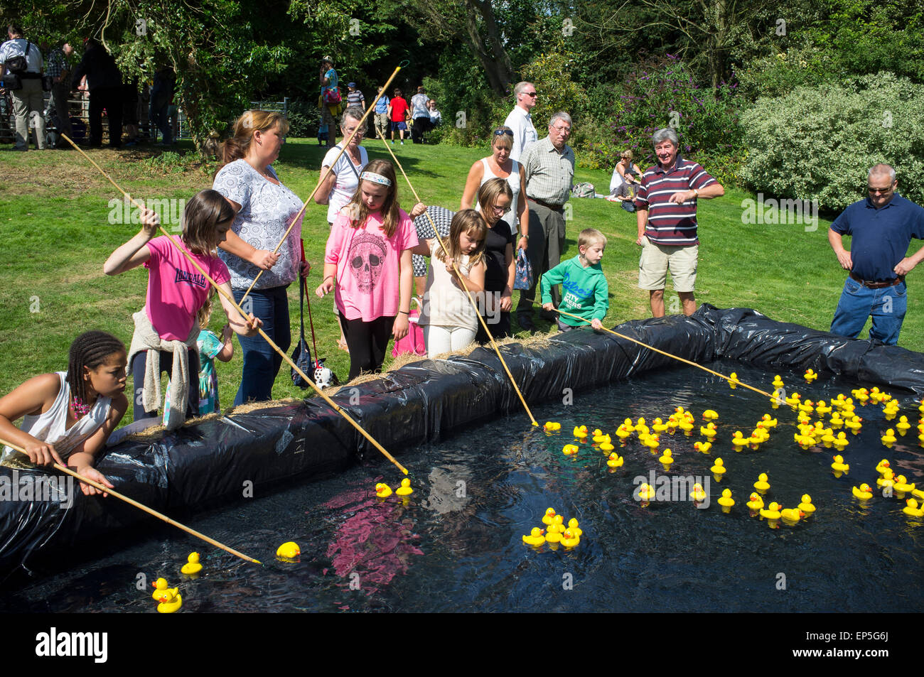 Children playing hook a duck at a traditional English summer fair Stock