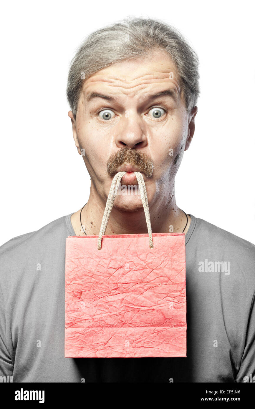 surprised mature man with shopping bag in mouth Stock Photo