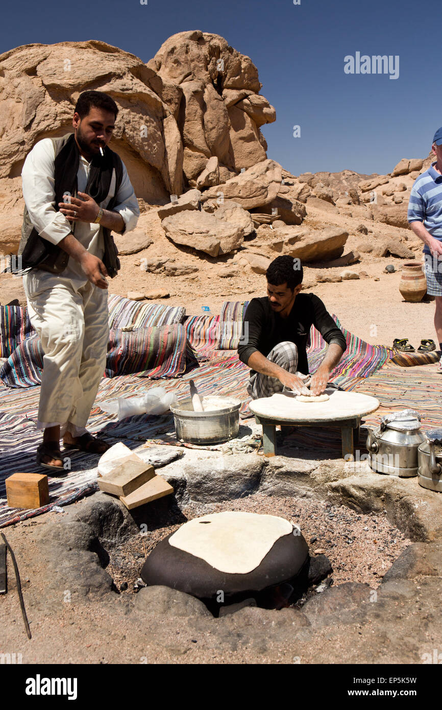 Egypt, Sinai,Bedouin Desert Camp, men making traditional fatir, or shrak flat bread on hot stone Stock Photo