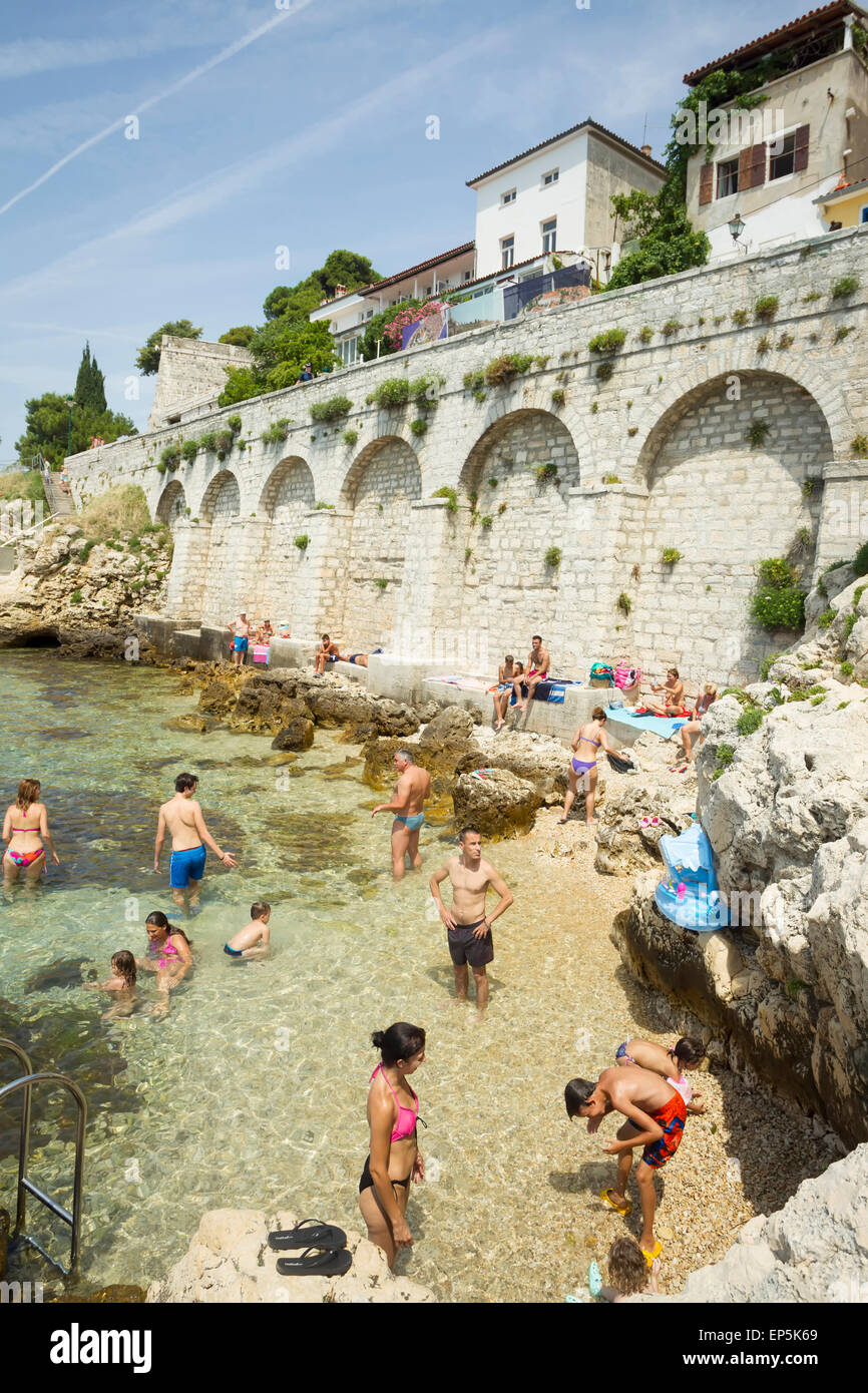 Bathing With Rocks People bathing in the shoal and sunbathing on the rocks of the city ...