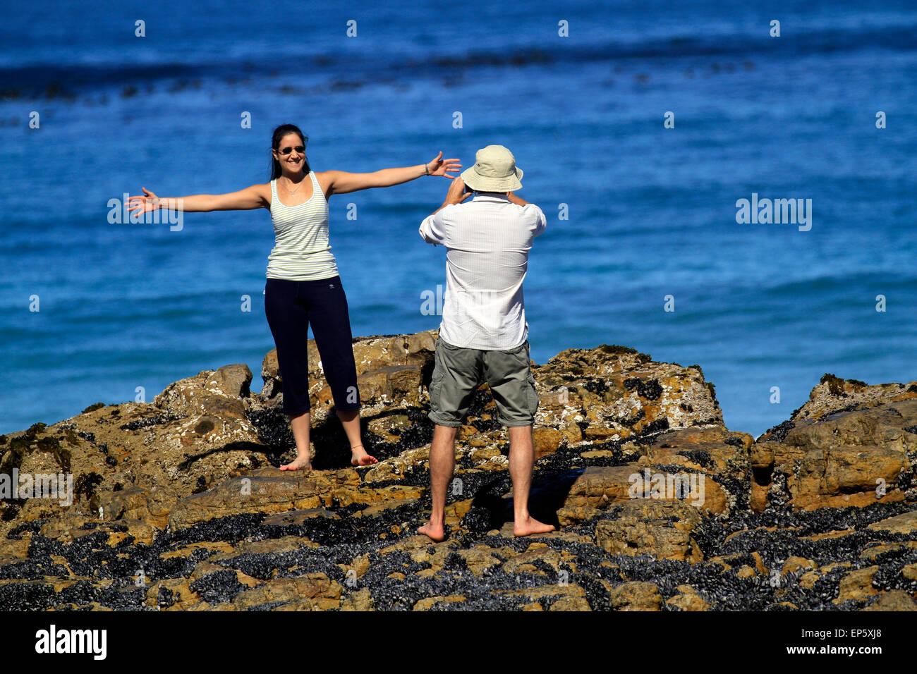 Woman posing for a photograph on the rocks at seaside village of Scarborough near Cape Town, South Africa. Stock Photo