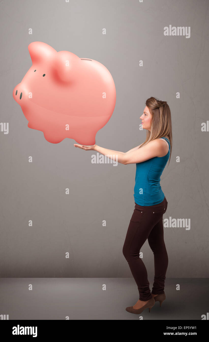 Young girl holding a huge savings piggy bank Stock Photo - Alamy