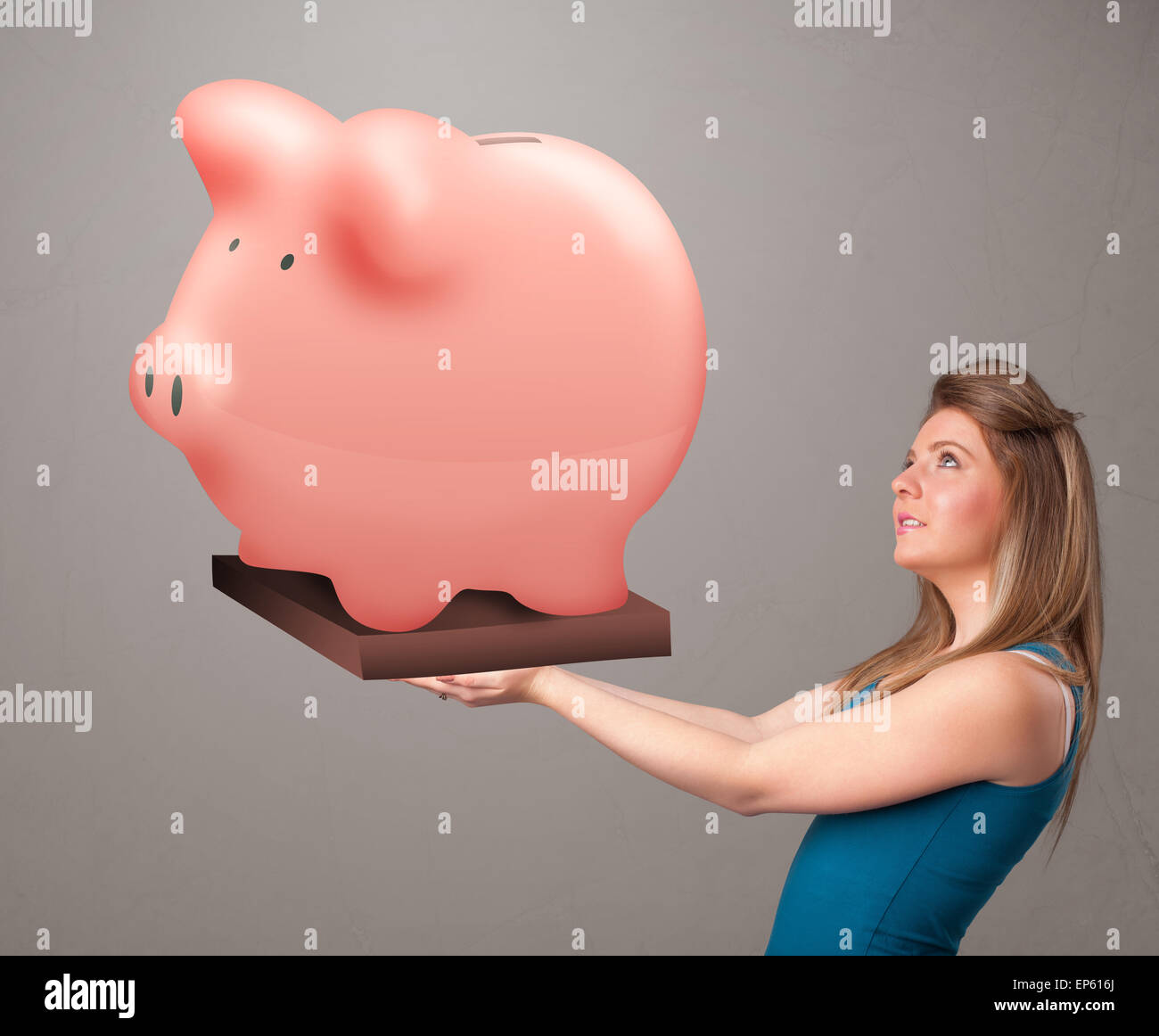 Young girl holding a huge savings piggy bank Stock Photo - Alamy