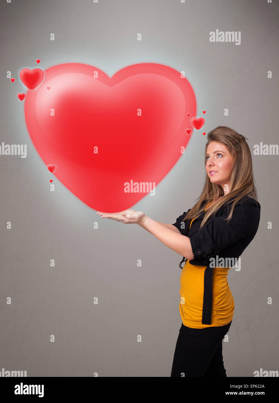 Young lady holding lovely 3d red heart Stock Photo - Alamy