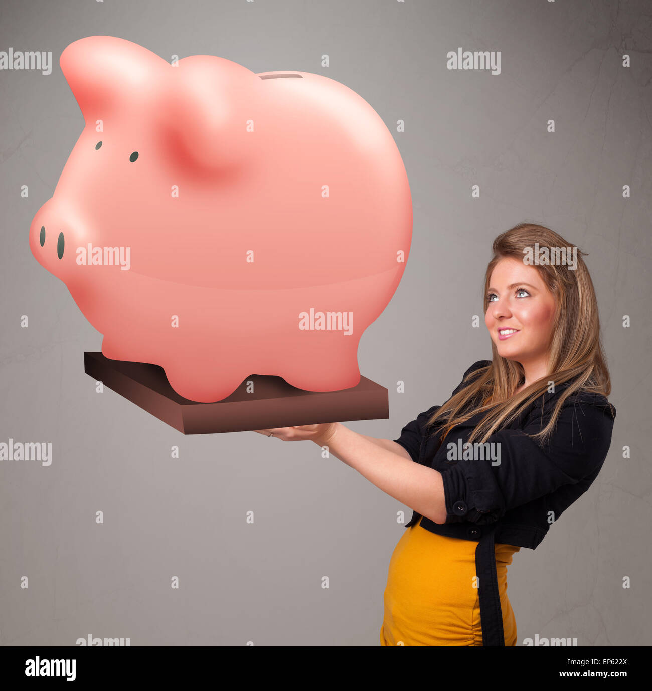 Young girl holding a huge savings piggy bank Stock Photo - Alamy