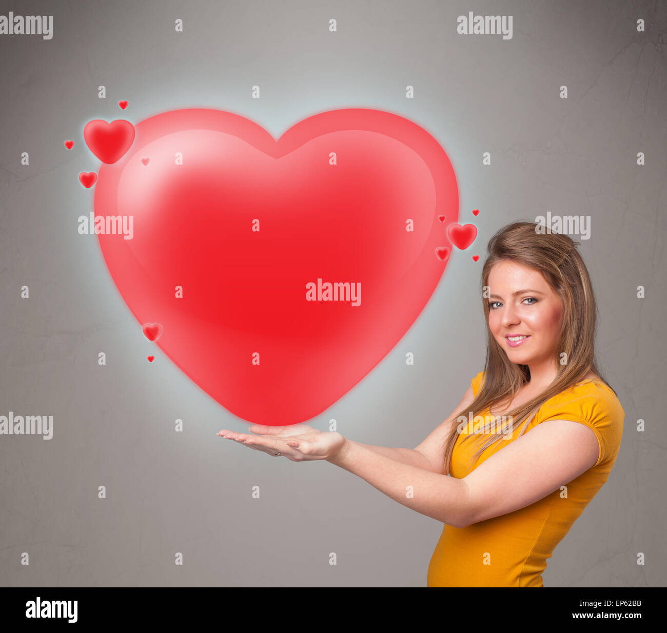 Young lady holding lovely 3d red heart Stock Photo - Alamy