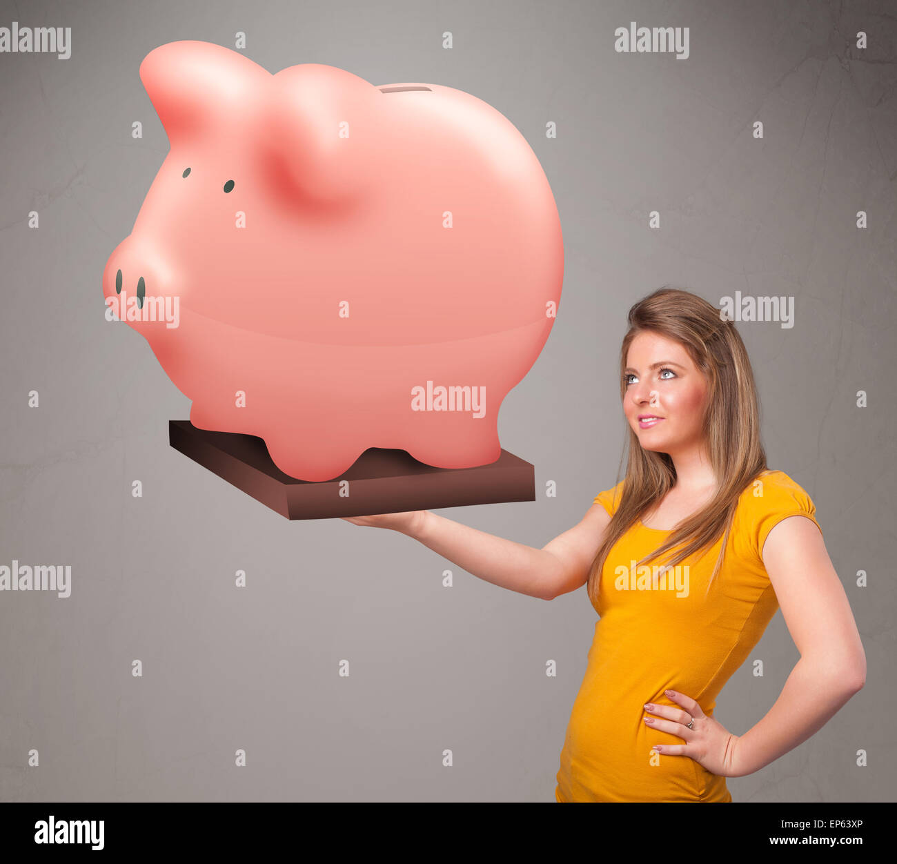 Young girl holding a huge savings piggy bank Stock Photo - Alamy