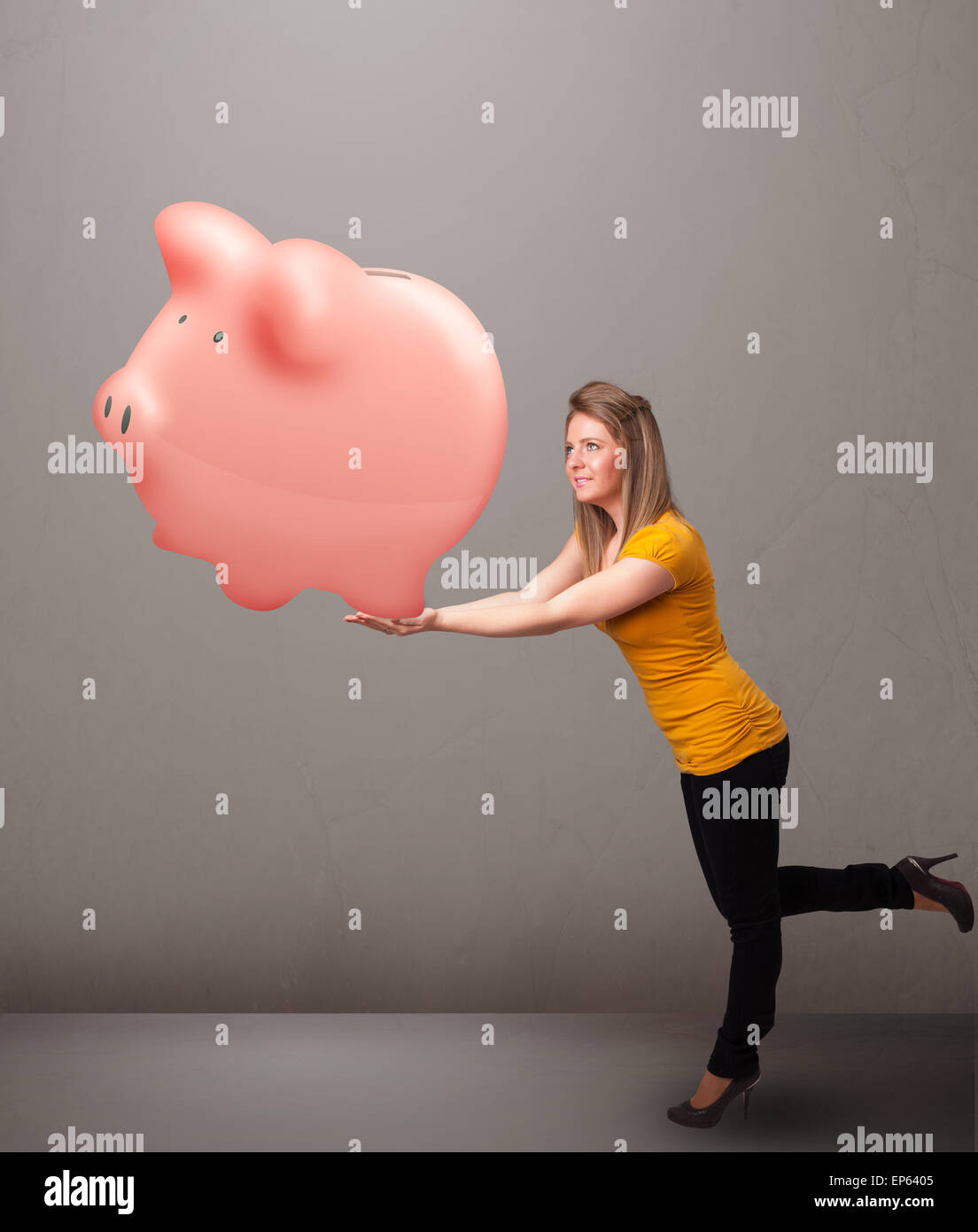 Young girl holding a huge savings piggy bank Stock Photo - Alamy