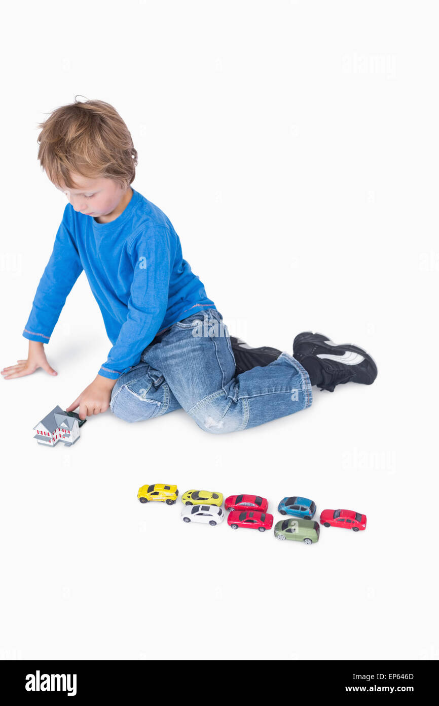 Young boy playing with playhouse and toy cars Stock Photo - Alamy