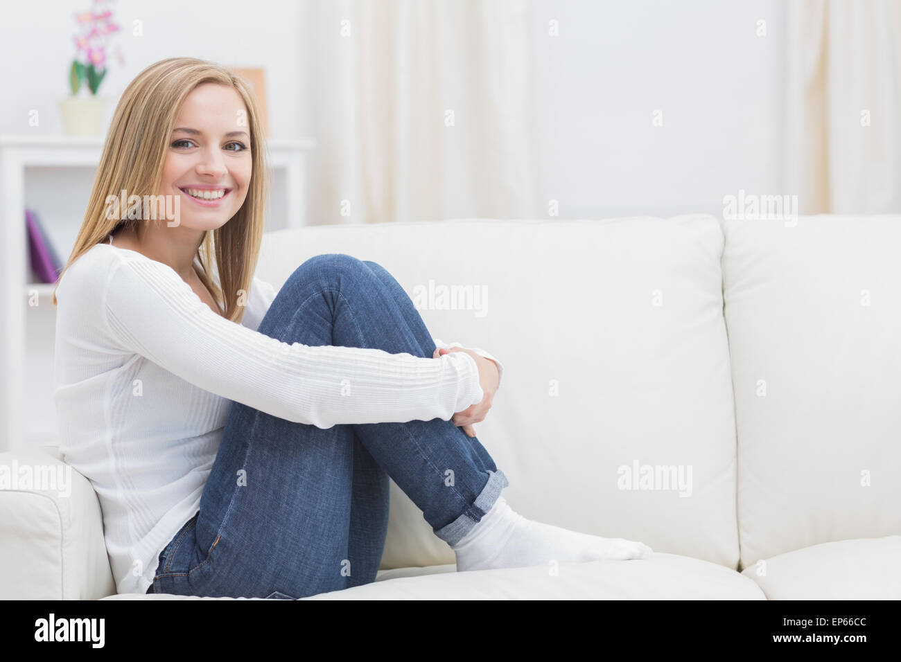 Portrait of casual happy woman sitting on sofa Stock Photo - Alamy