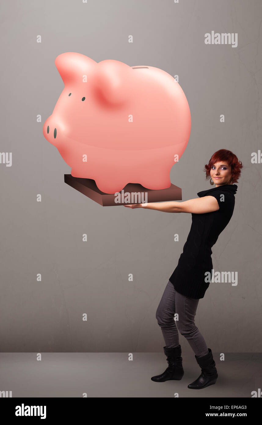 Young girl holding a huge savings piggy bank Stock Photo - Alamy