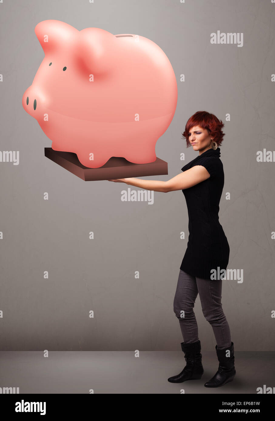 Young girl holding a huge savings piggy bank Stock Photo - Alamy