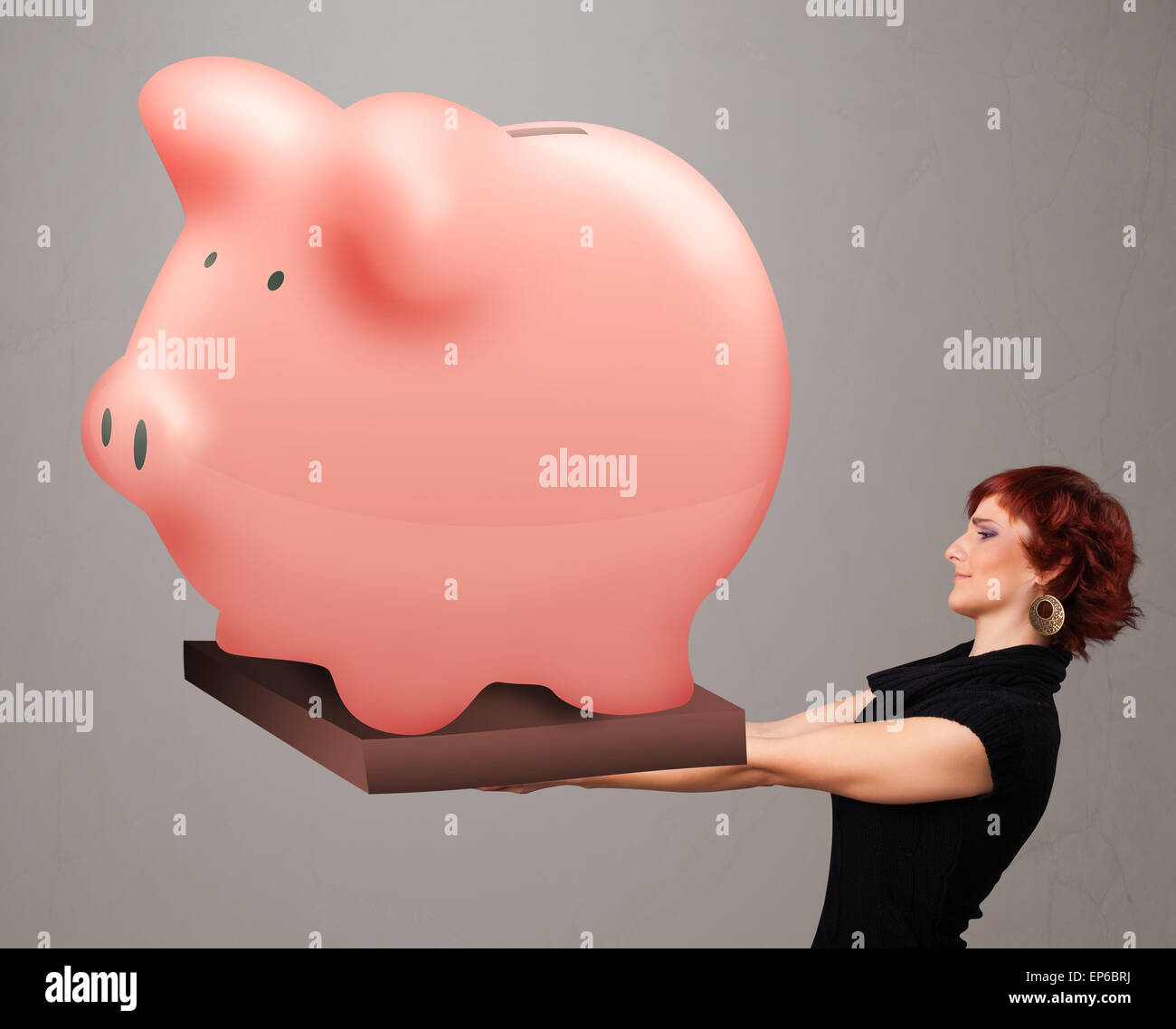 Young girl holding a huge savings piggy bank Stock Photo - Alamy
