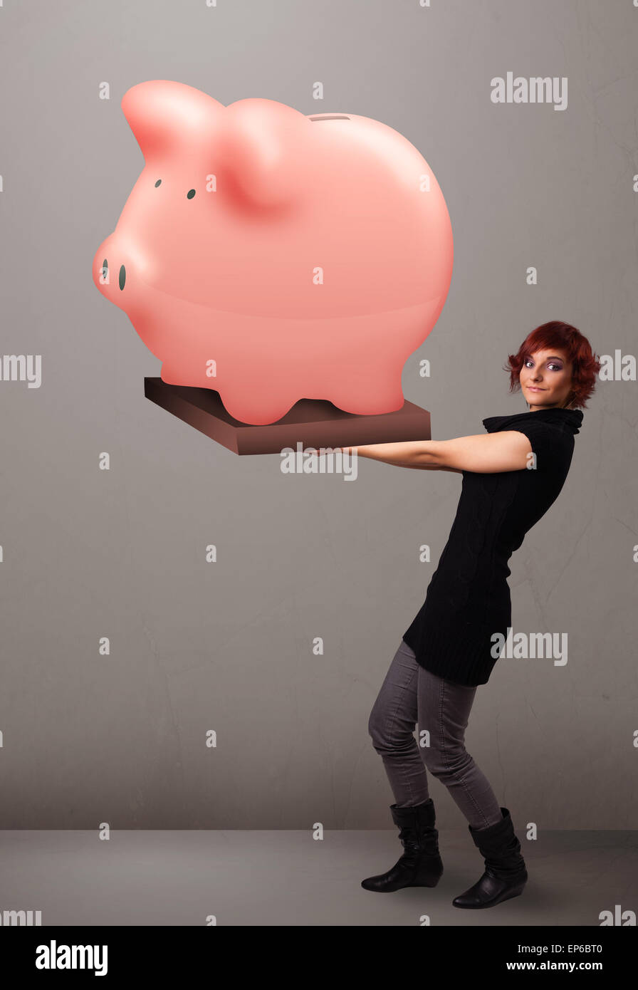Young girl holding a huge savings piggy bank Stock Photo - Alamy