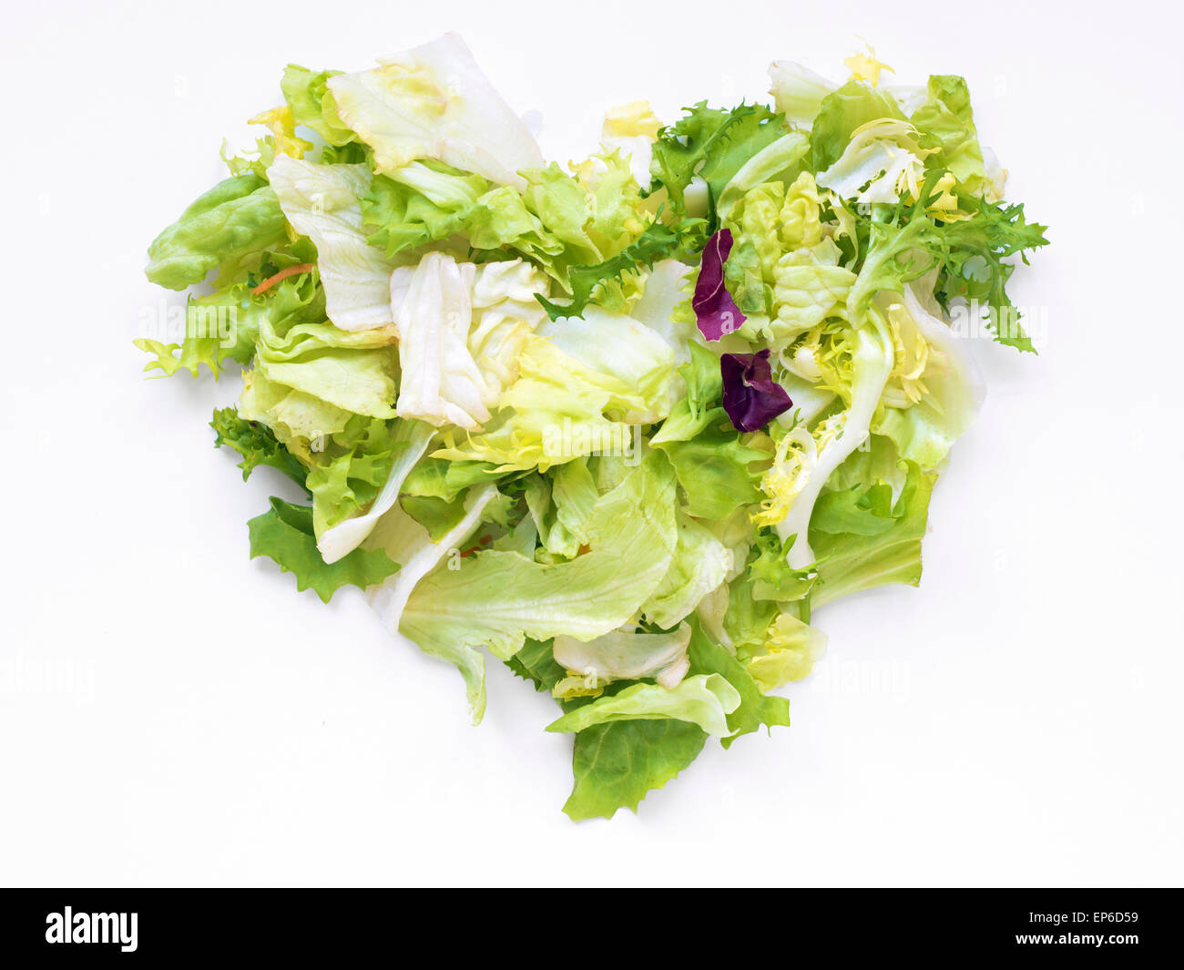 mixed salad of fresh vegetables in shape of heart on white background Stock Photo