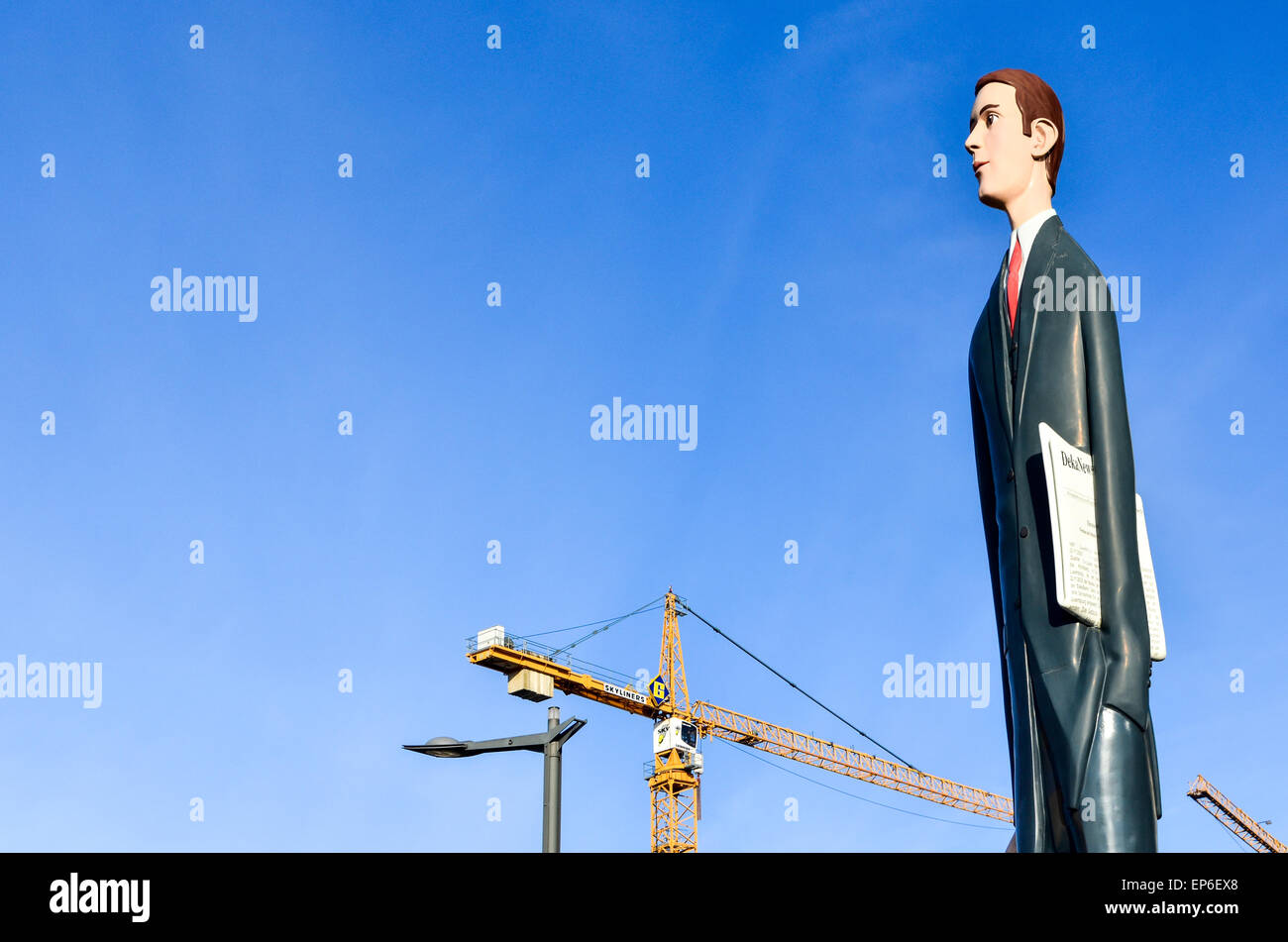 Statue of 'The Tall Banker' in Kirchberg, Luxembourg City, and construction cranes in the background Stock Photo