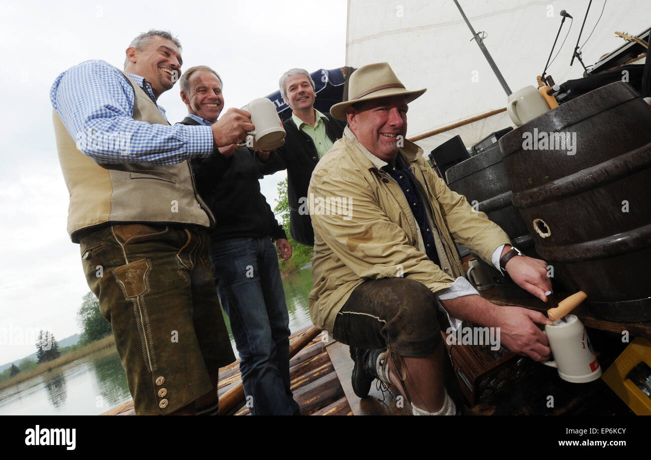 Four fathers hold beer mugs while one taps the keg on Father's Day