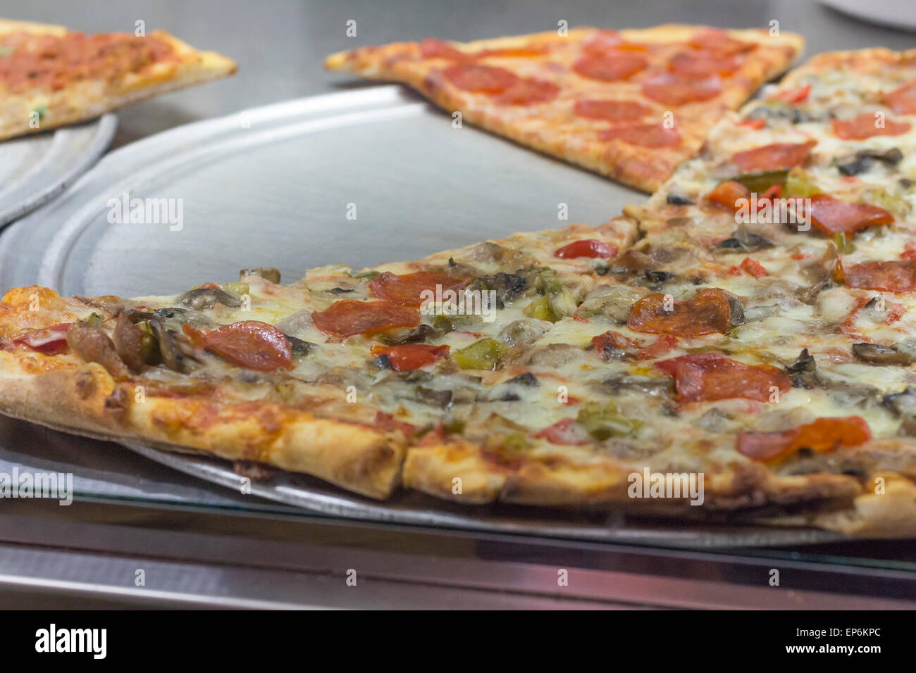 Large slice of pepperoni sausage and mushroom pizza New York style