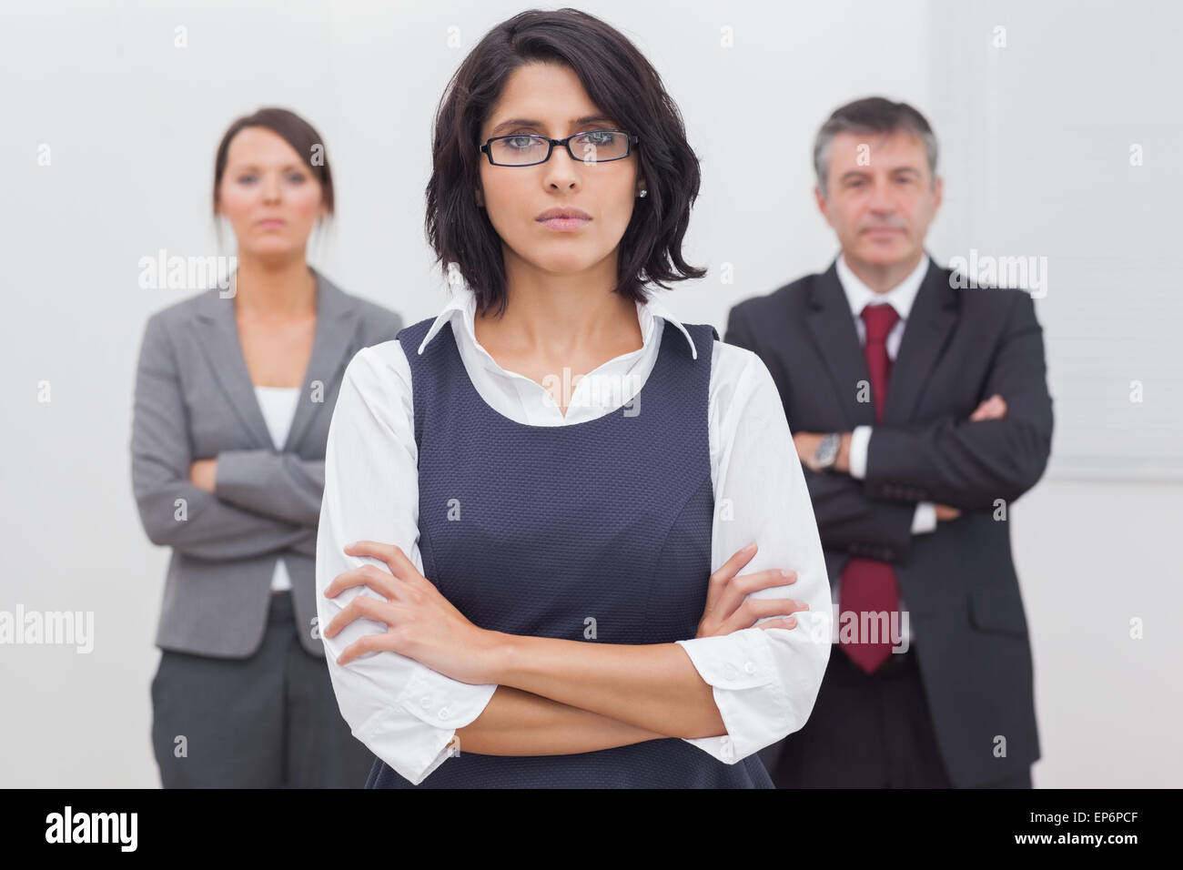 Three business people folding their arms seriously Stock Photo Alamy