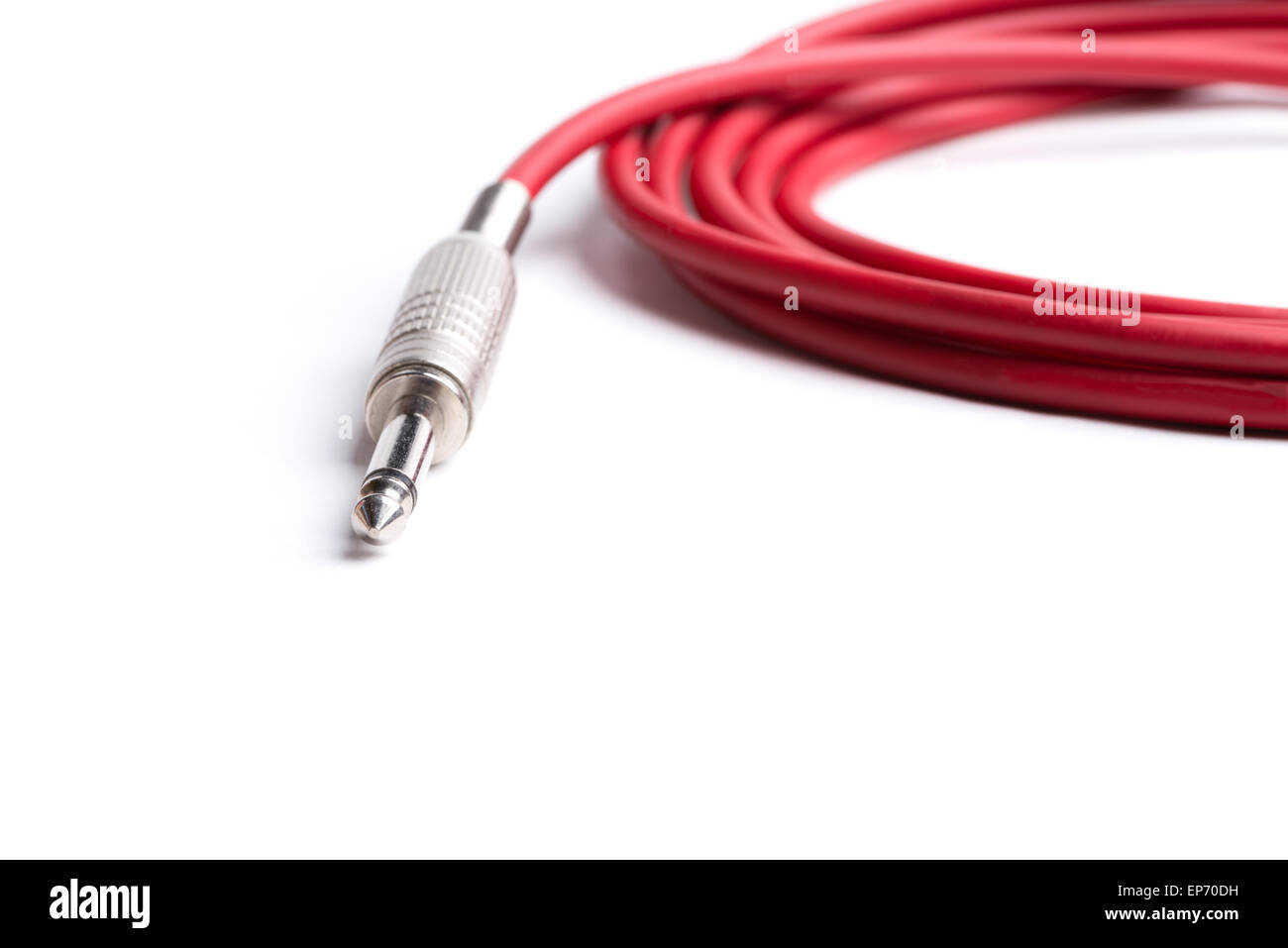 A red quarter inch cable for electric guitar isolated on a white