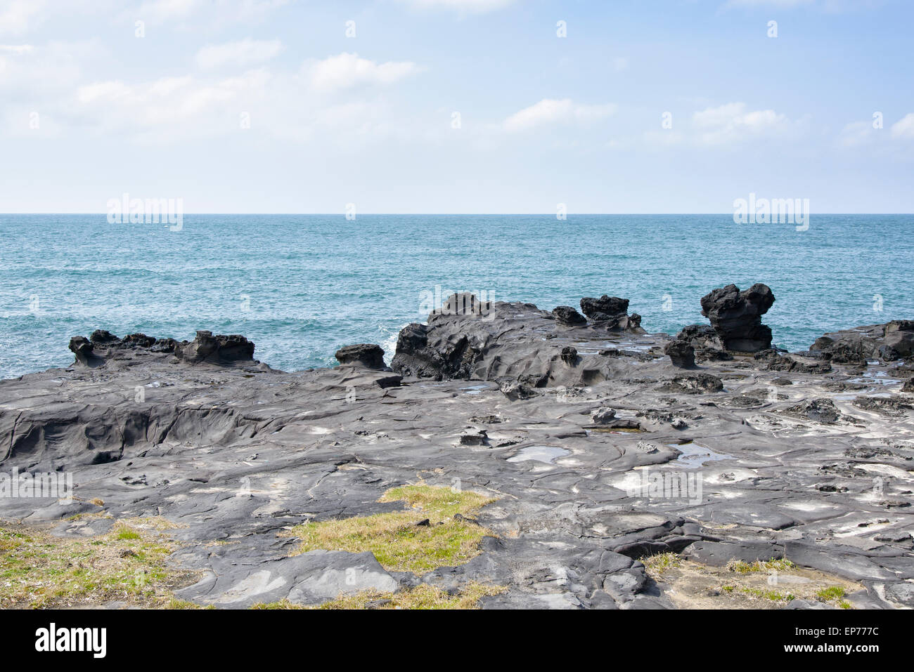 Landscape with distinctive geological rock coast in Jeju Island, Korea. It is near the Jeju Olle trail route 16. Stock Photo