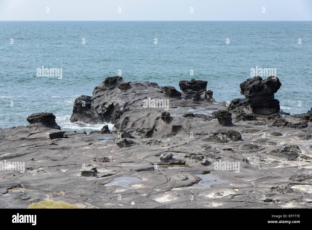 Landscape with distinctive geological rock coast in Jeju Island, Korea. It is near the Jeju Olle trail route 16. Stock Photo