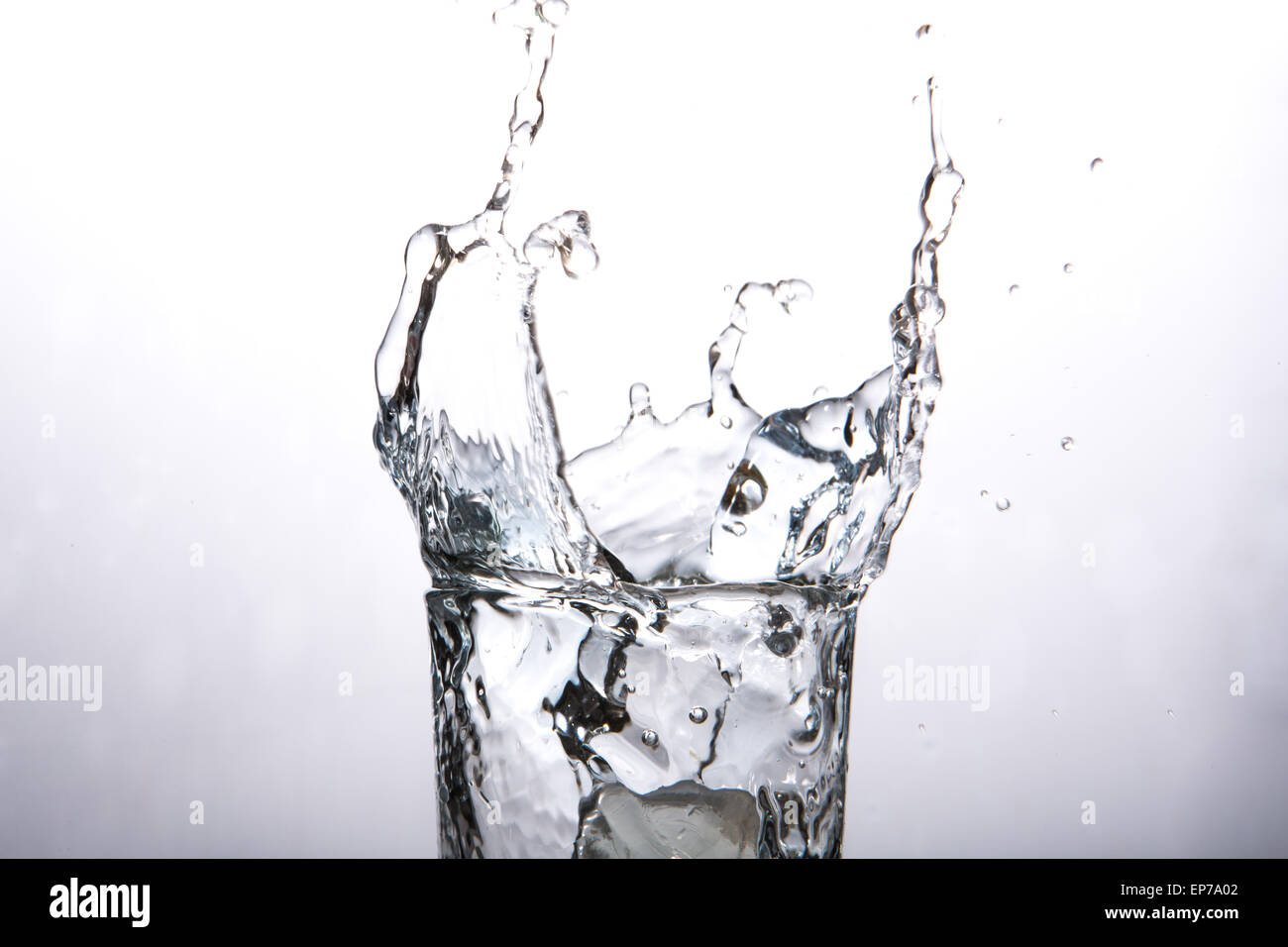 Close up on ice cube falling into glass of water Stock Photo - Alamy