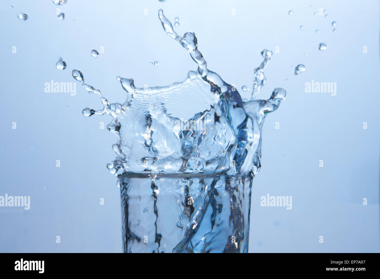 Close up on ice cube falling into glass of water Stock Photo - Alamy